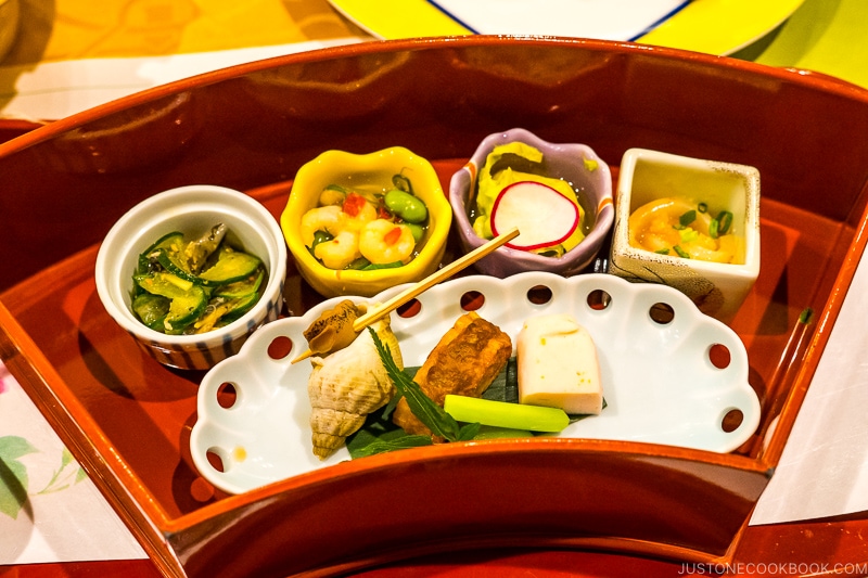 appetizer served in small dishes in a fan shaped wooden box