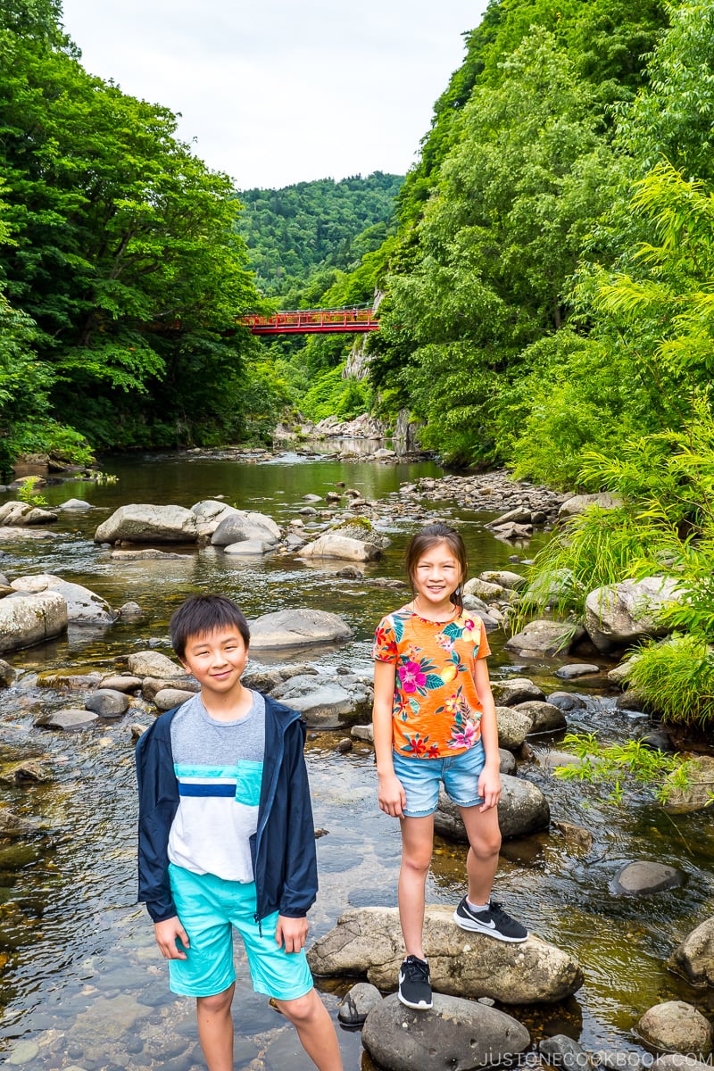 two children standing on rock on the Toyohira River