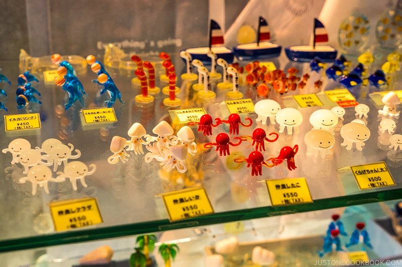 assorted creatures made from glass on a glass shelf