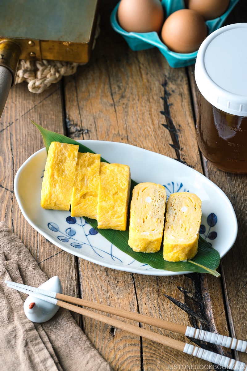 An oval plate containing Japanese sweet rolled omelet.