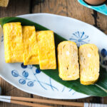 An oval plate containing Japanese sweet rolled omelet.