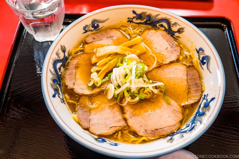 chashu ramen in a white bowl on top of a black tray