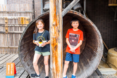 two children standing in a large wood vat