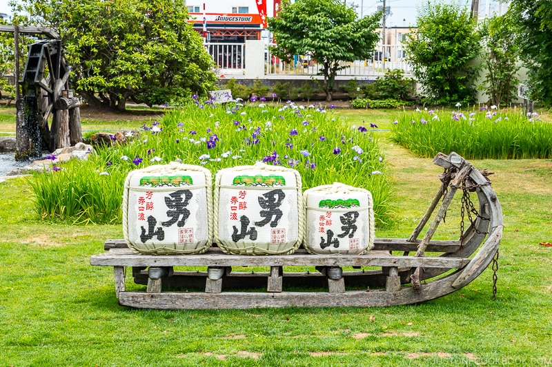 sake barrels on a sled on top of grass in a garden