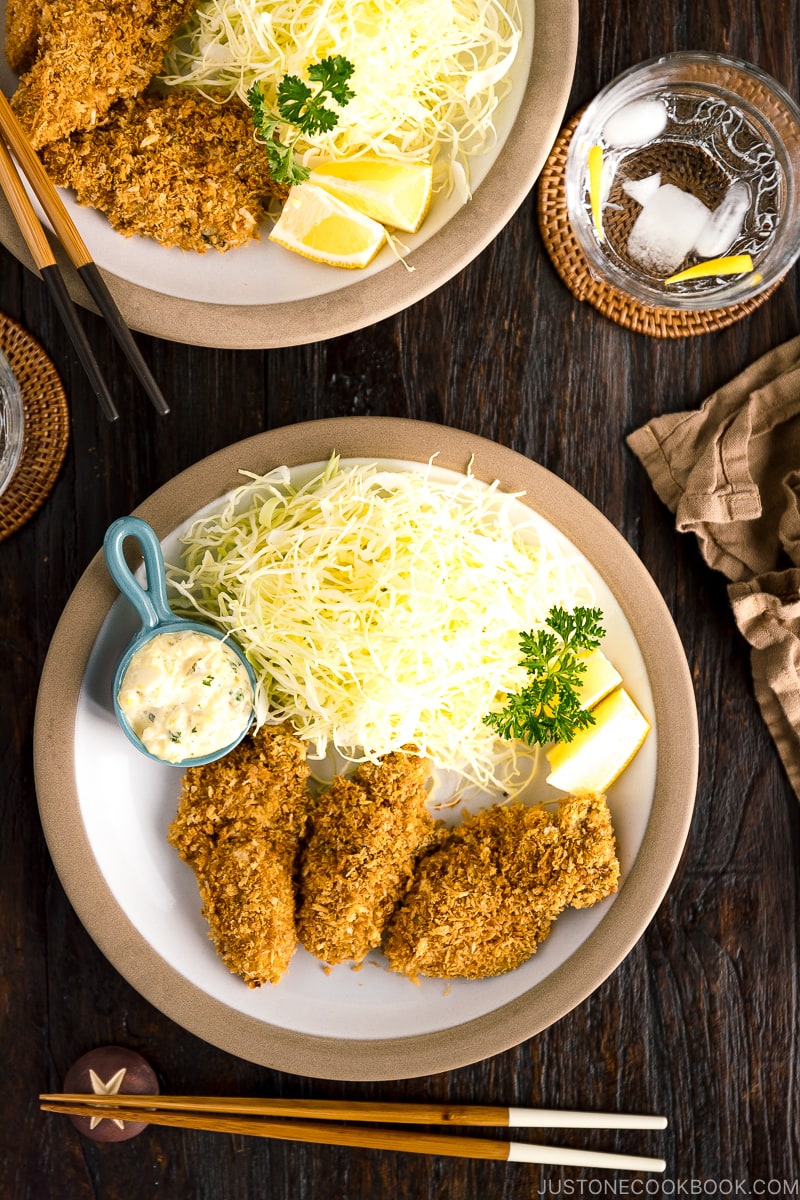 A plate containing fried oyster (kaki furai) along with shredded cabbage and tartar sauce.