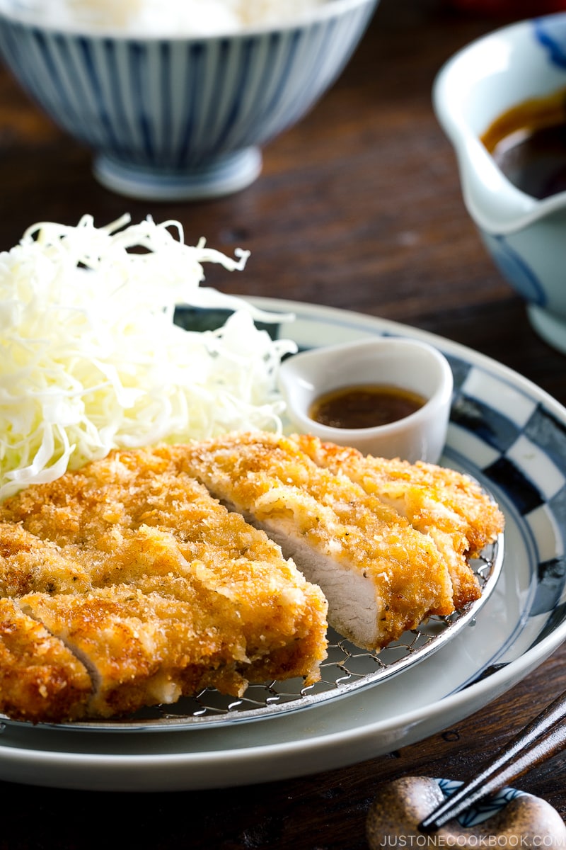 A plate containing Tonkatsu, shredded cabbage, and a small bowl of miso sauce.