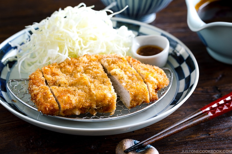 A plate containing Tonkatsu, shredded cabbage, and a small bowl of miso sauce.