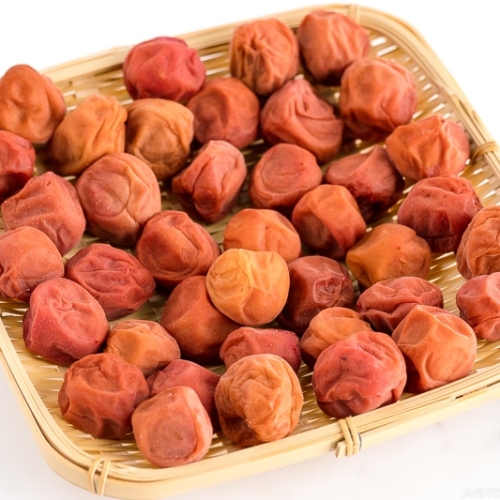 A bamboo strainer containing umeboshi (Japanese pickled plums).