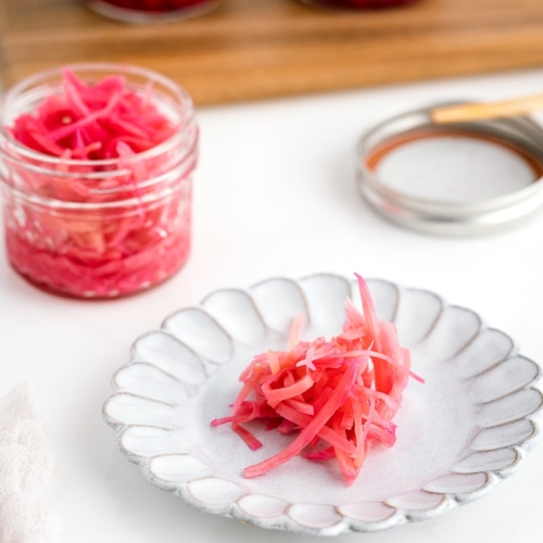 Mason jars containing beni shoga (Japanese red pickled ginger).