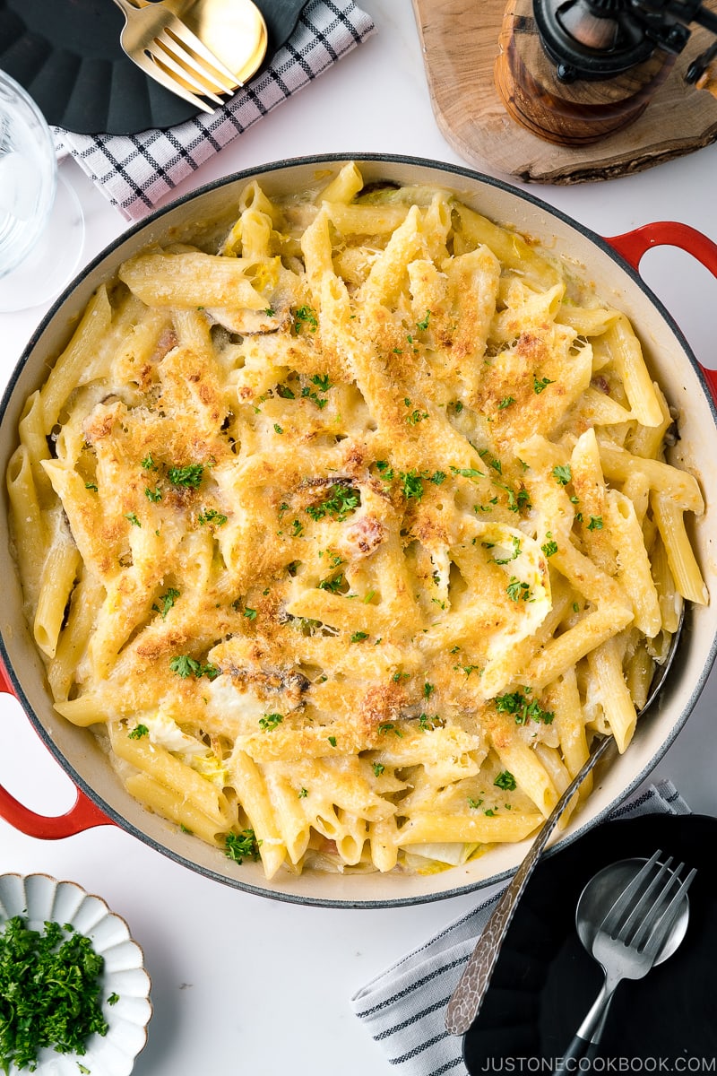 A Le Creuset braiser containing creamy napa cabbage and bacon pasta.