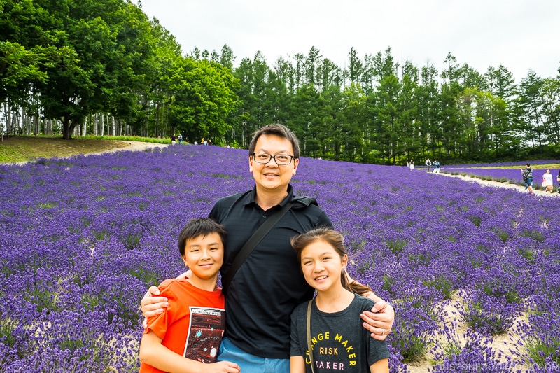 a man and two children in front of large lavender field
