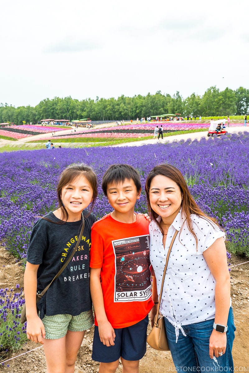 a woman with two children in front of flower fields