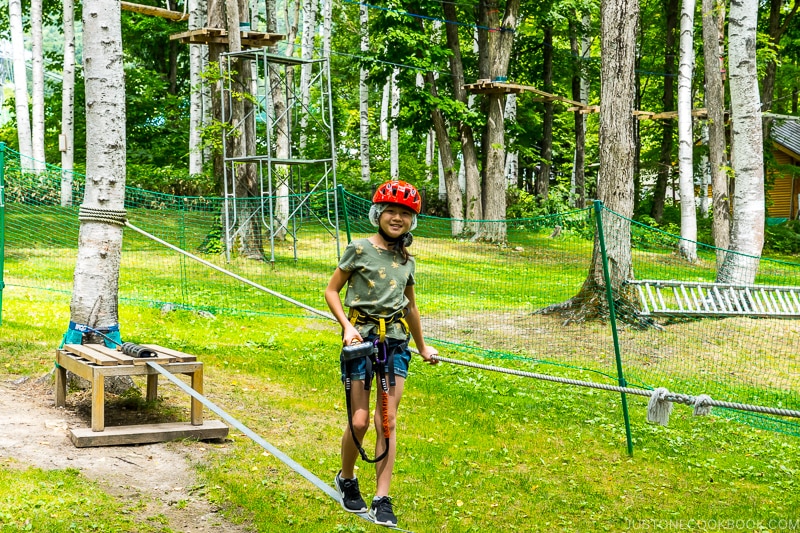 a girl on the rope course at Tree Adventure Furano