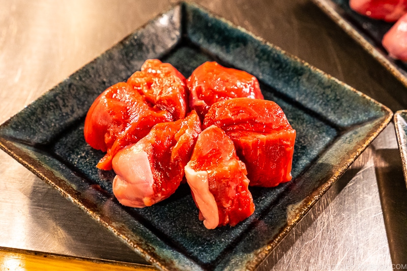 piece of uncooked lamb on black plates