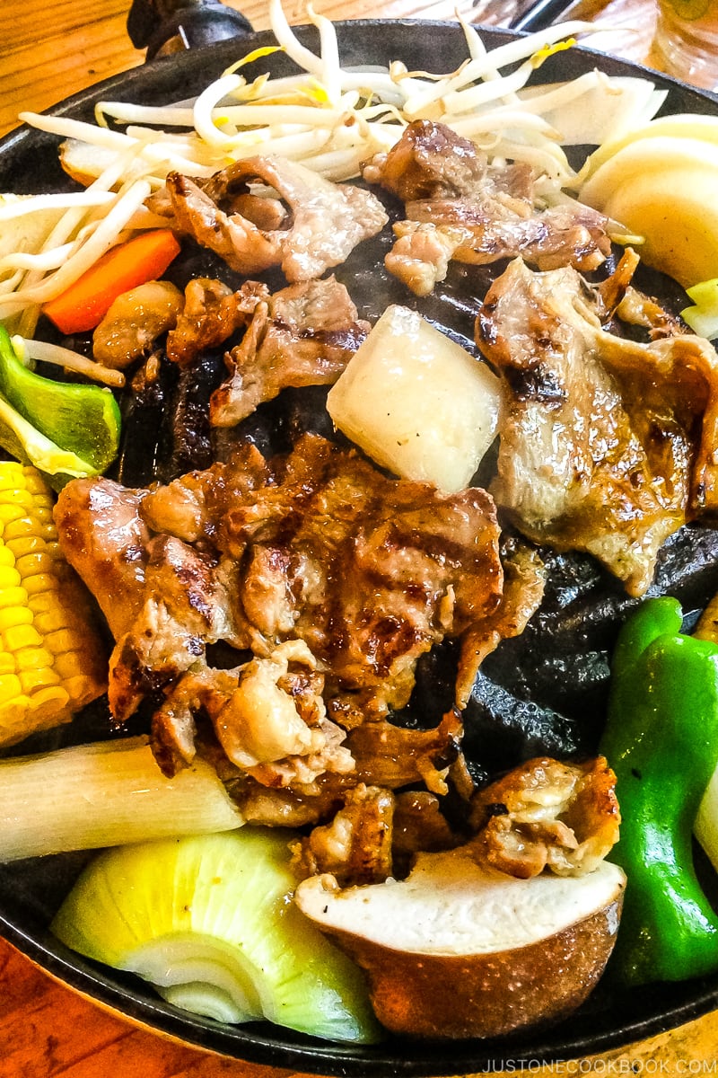 lamb, onion, mushroom, pepper, corn, and bean sprout grilling on metal grate