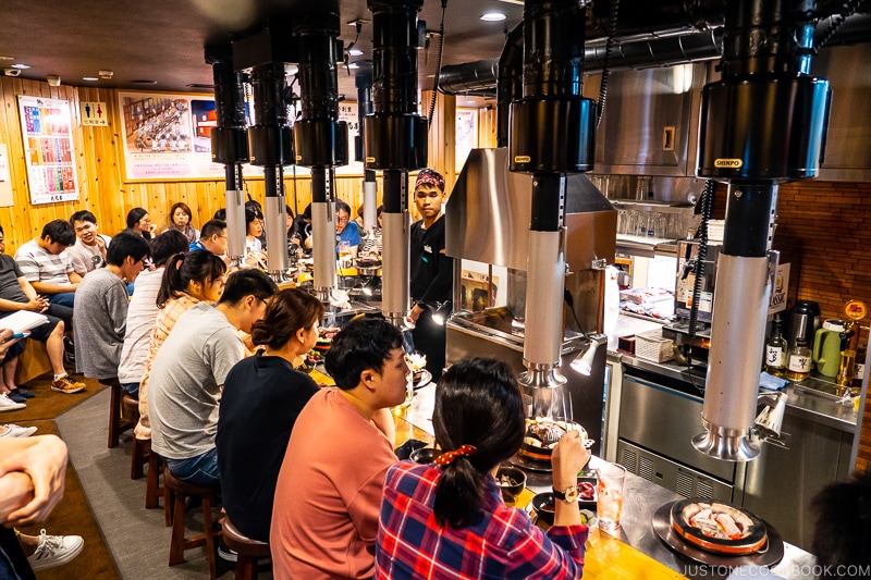 customer sitting in front of table grills