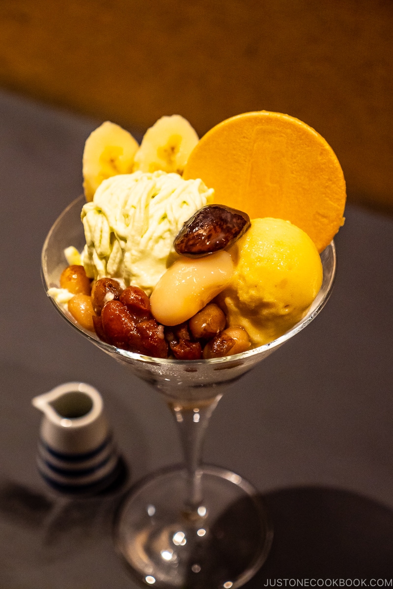 a parfait with banana andred bean in a glass on table