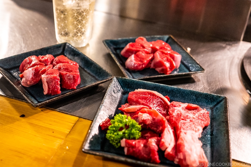 piece of uncooked lamb on black plates