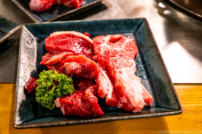 piece of uncooked lamb on black plates