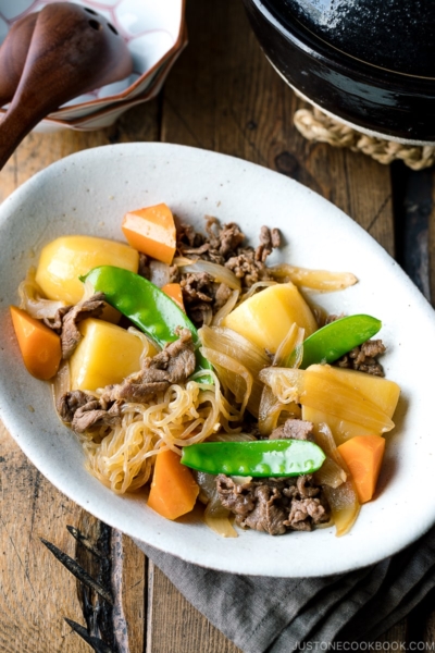 A white oval plate containing Nikujaga (Japanese Meat and Potato Stew).