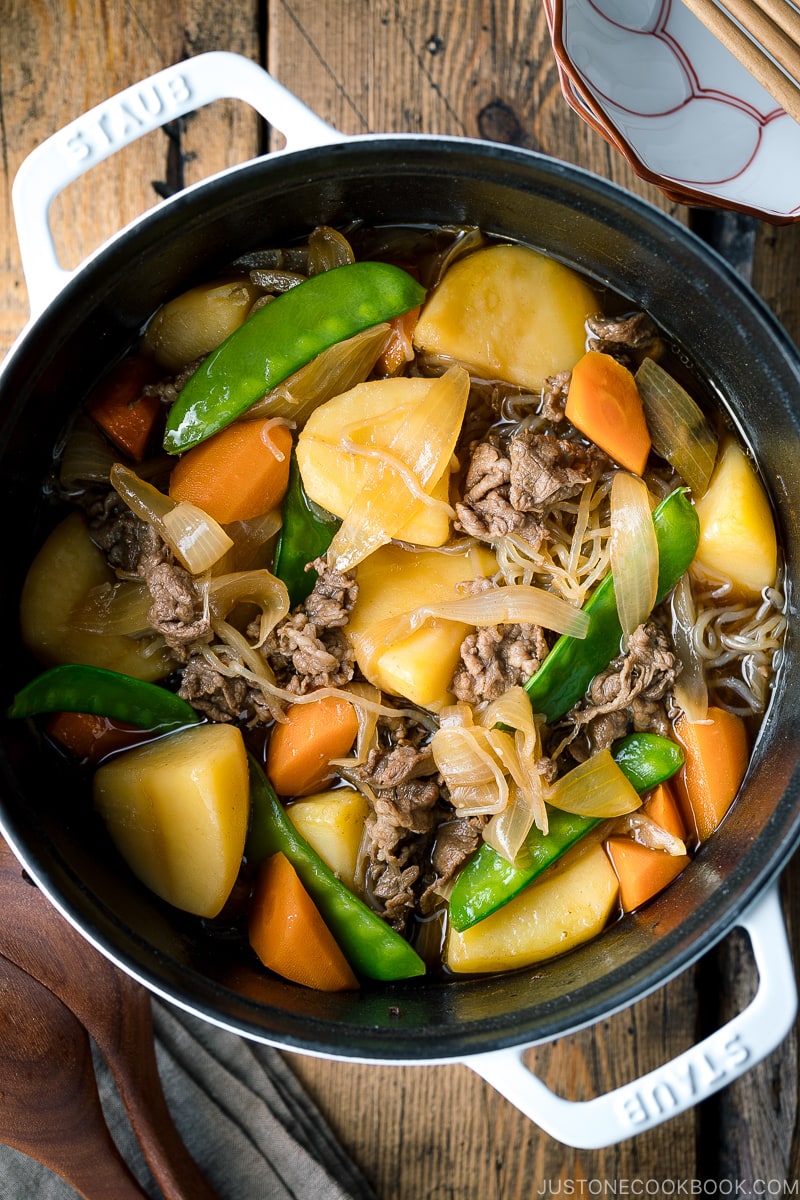 A white Staub pot containing Nikujaga (Japanese Meat and Potato Stew).