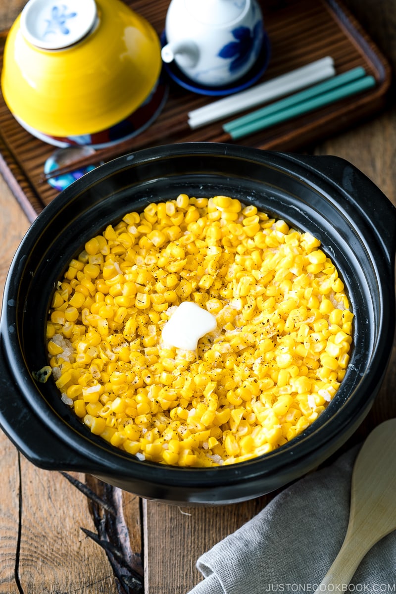 A donabe pot containing Japanese Corn Rice (Butter Shoyu Flavor) topped with melted butter.