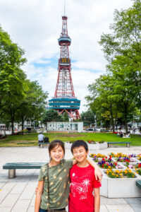 two children standing in front of Sapporo TV Tower