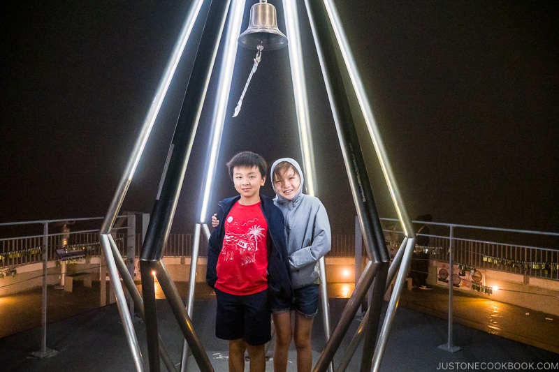 two children standing in a lighted metal structure