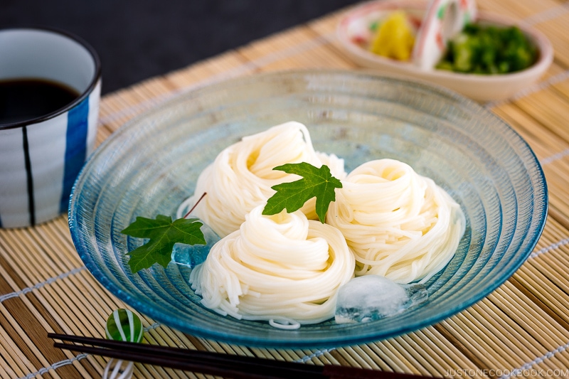 A blue glass bowl containing somen noodles.