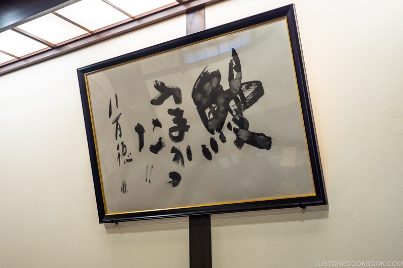 a framed sign with Japanese writing