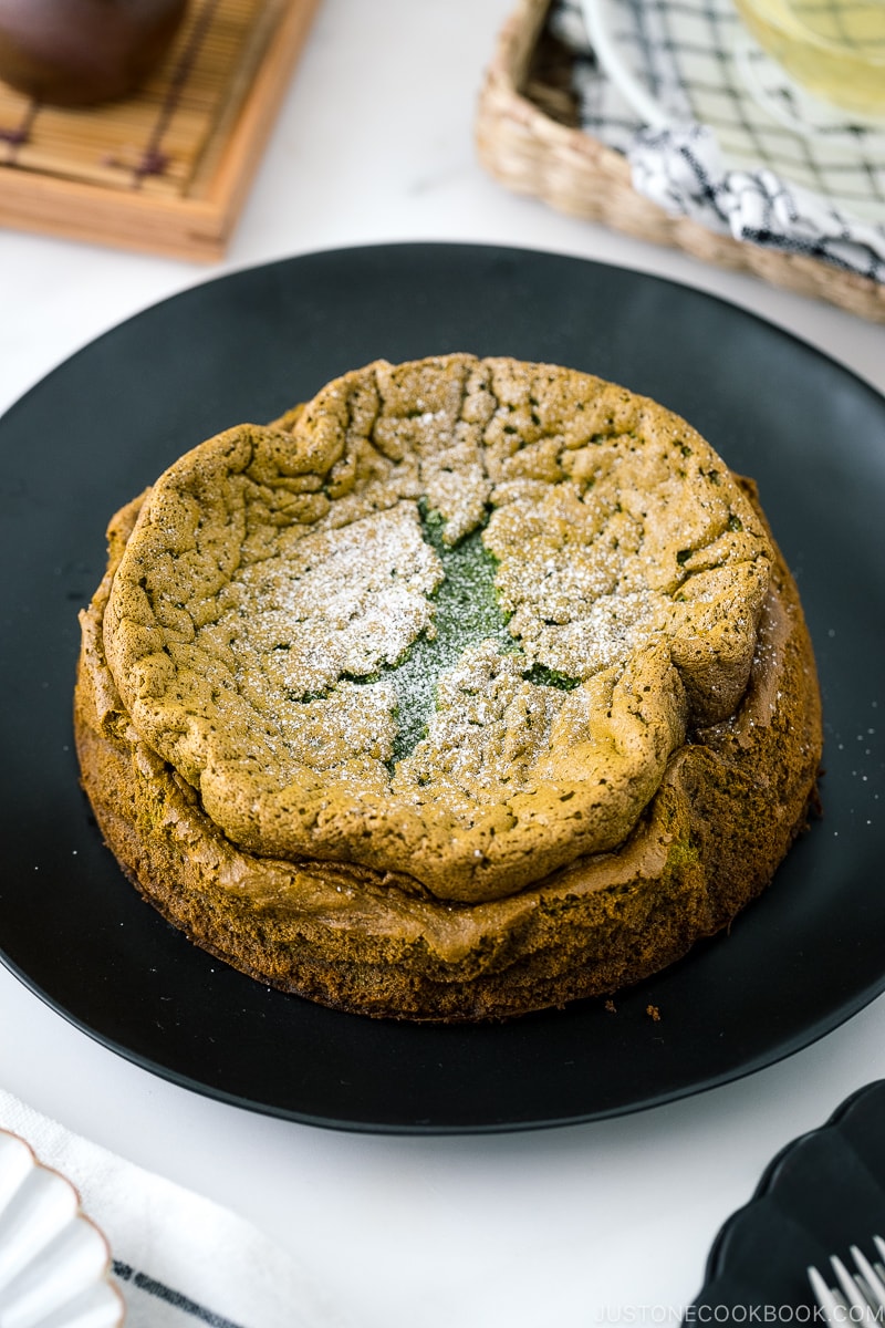 A black plate containing Matcha Gateau au Chocolat dusted with powdered sugar.