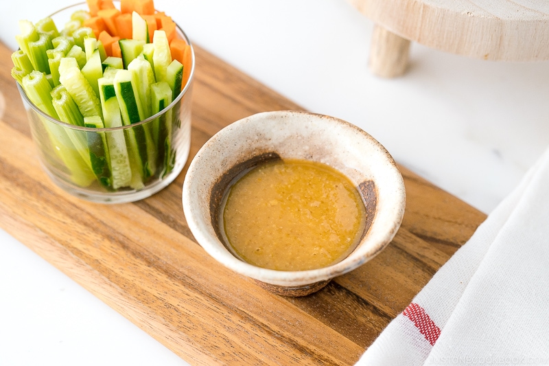 Ume Miso Dip with stick vegetables on a cutting board.