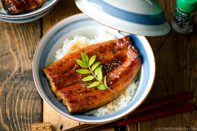 A donburi bowl containing grilled eel fillet over steamed rice.