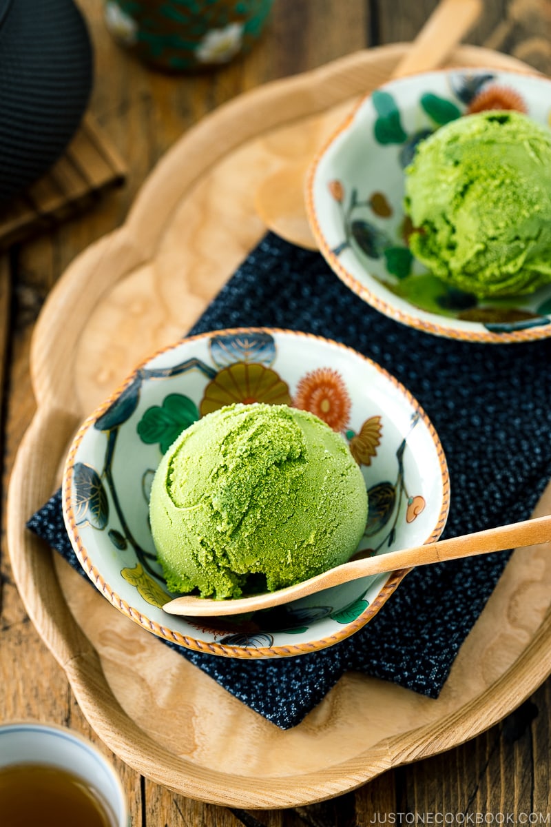 A Japanese kutaniware bowl containing matcha green tea ice cream served with a wooden spoon.