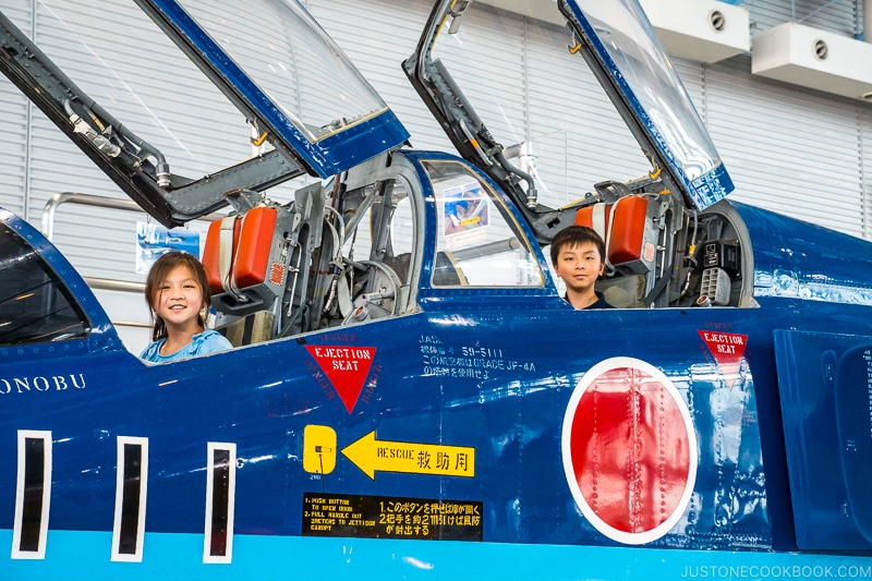 two children sitting in jet cockpit