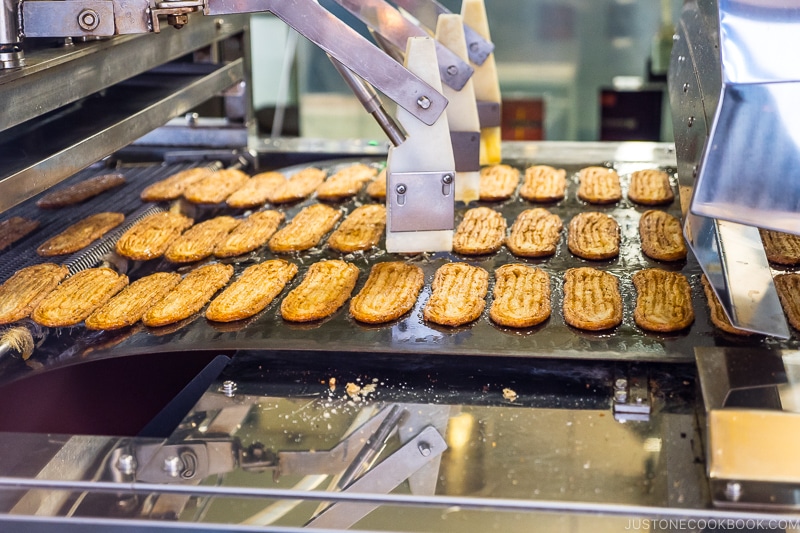 machine brushing butter on unagi pie