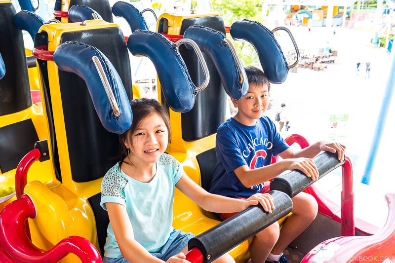 kids sitting inside a roller coaster