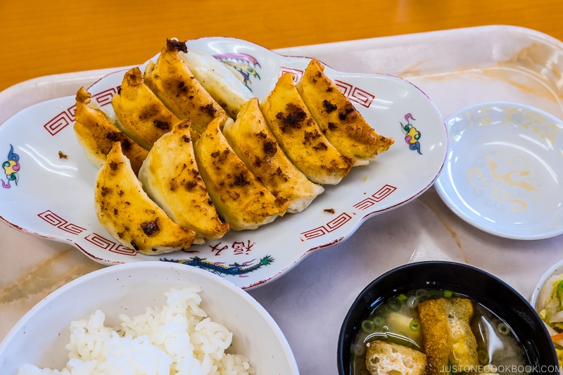 gyoza on a plate next to rice and soup
