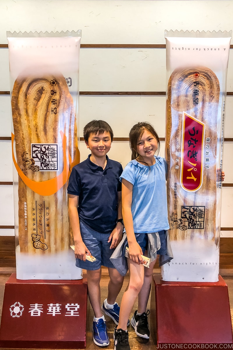 two children standing next to unagi pie