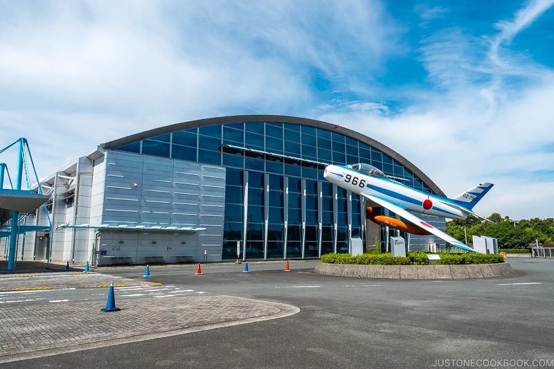 an airplane in front of a large building