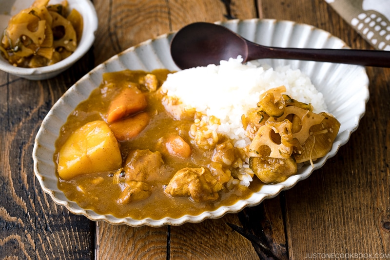 A oval plate containing Japanese curry rice garnished with homemade fukujinzuke.