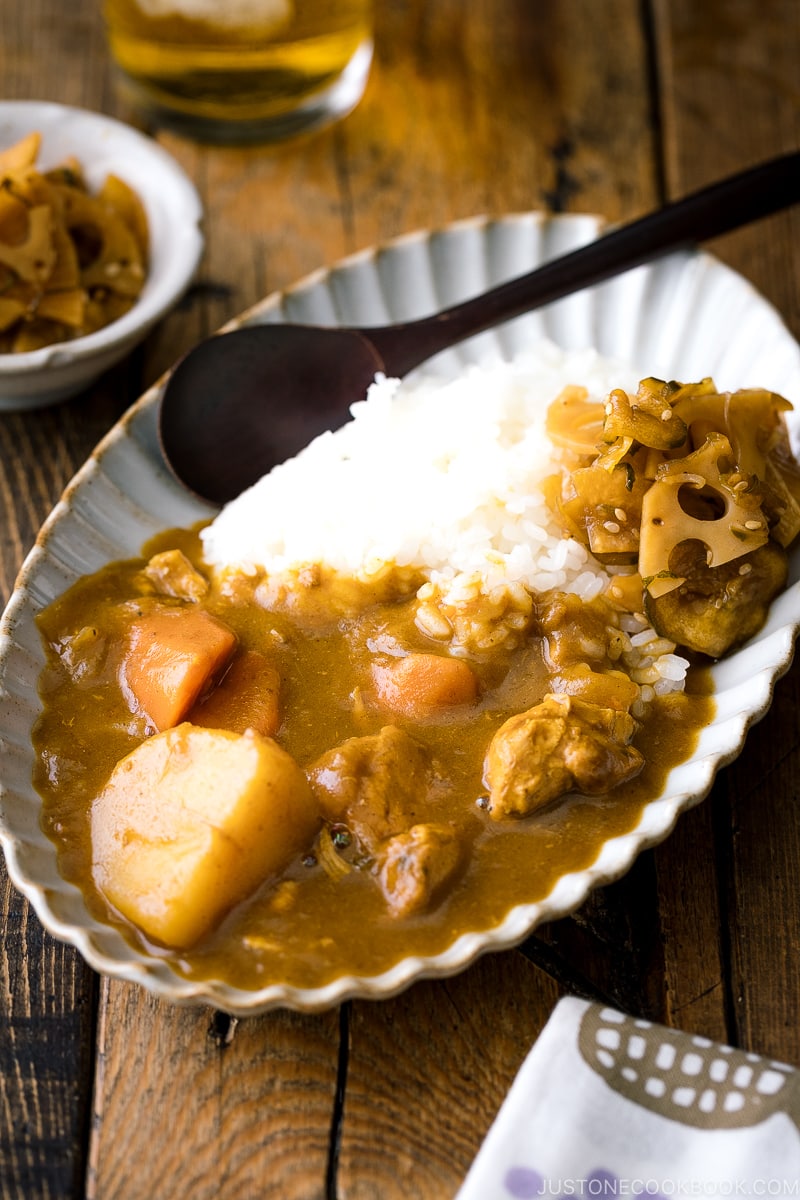 A oval plate containing Japanese curry rice garnished with homemade fukujinzuke.