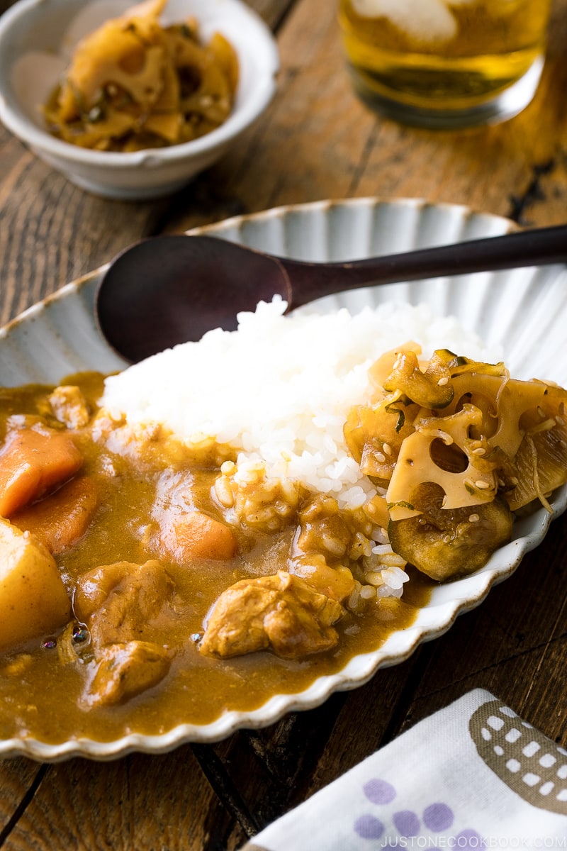 A oval plate containing Japanese curry rice garnished with homemade fukujinzuke.