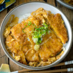 A ceramic bowl containing Katsudon (Japanese Pork Cutlet Rice Bowl).