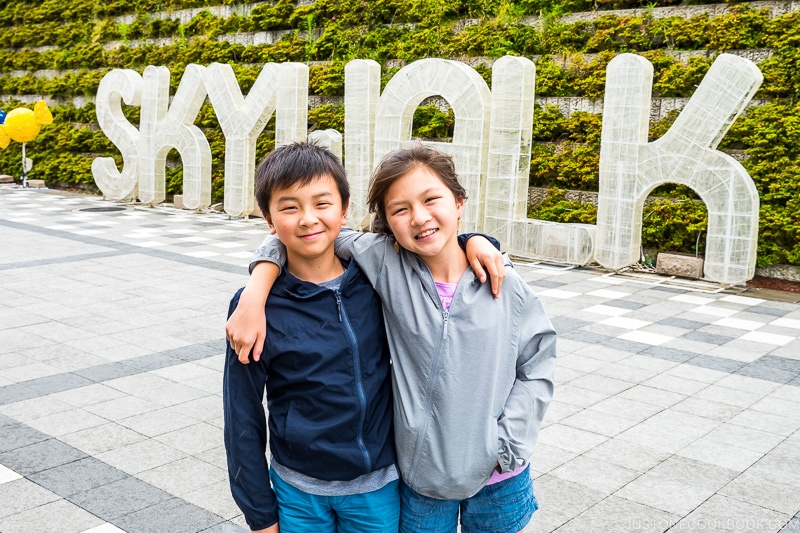 two children in front of Skywalk sign