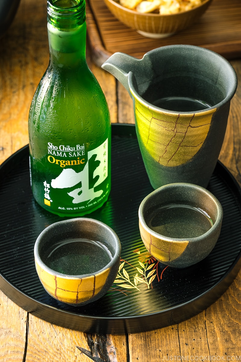 A lacquer tray containing Japanese sake bottle and ceramic sake set.