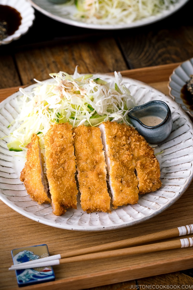 A Japanese ceramic containing Tonkatsu (pork cutlet) and shredded cabbage salad.