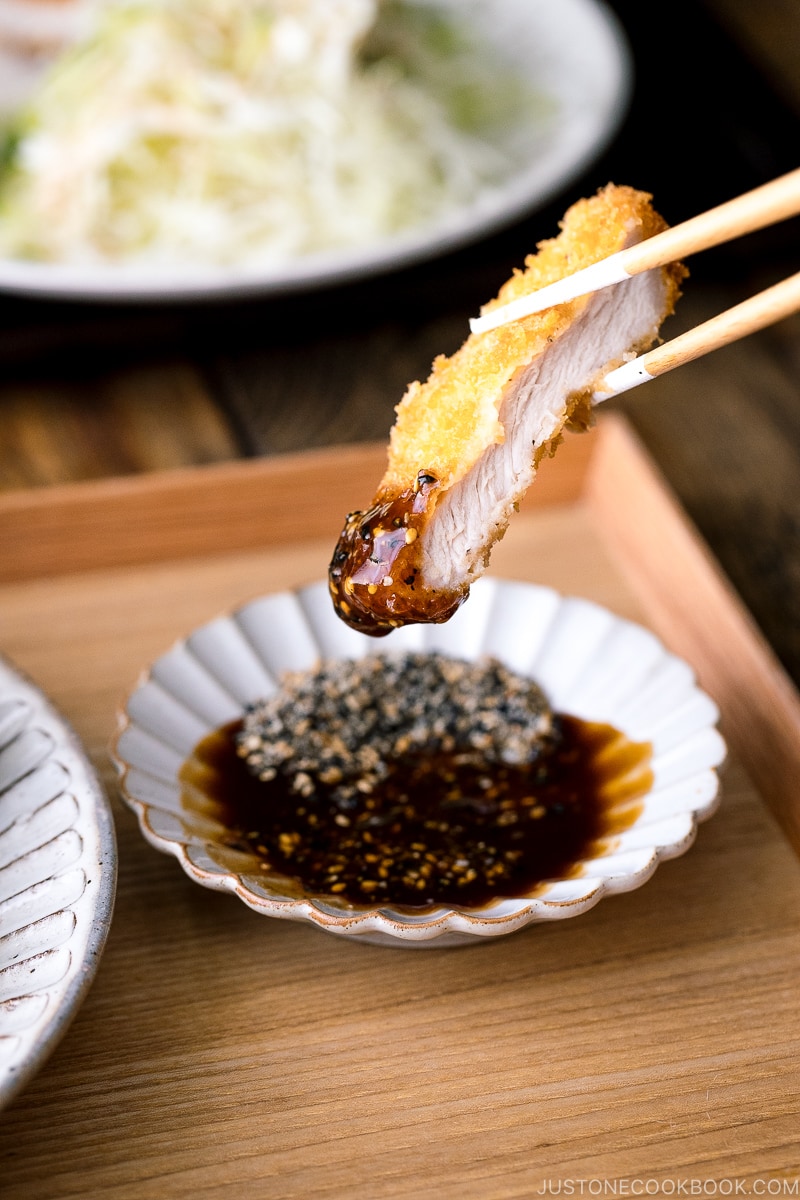 Tonkatsu dipping into Tonkatsu sauce.