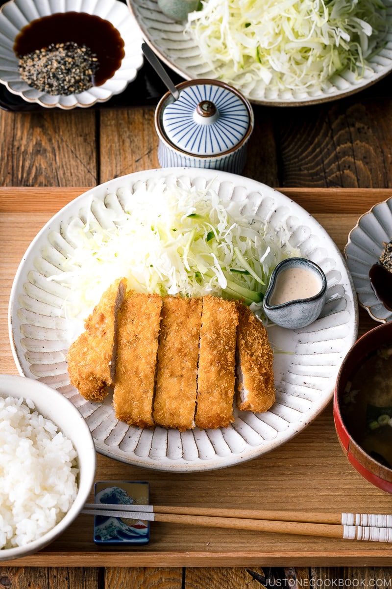 A Japanese ceramic containing Tonkatsu (pork cutlet) and shredded cabbage salad.