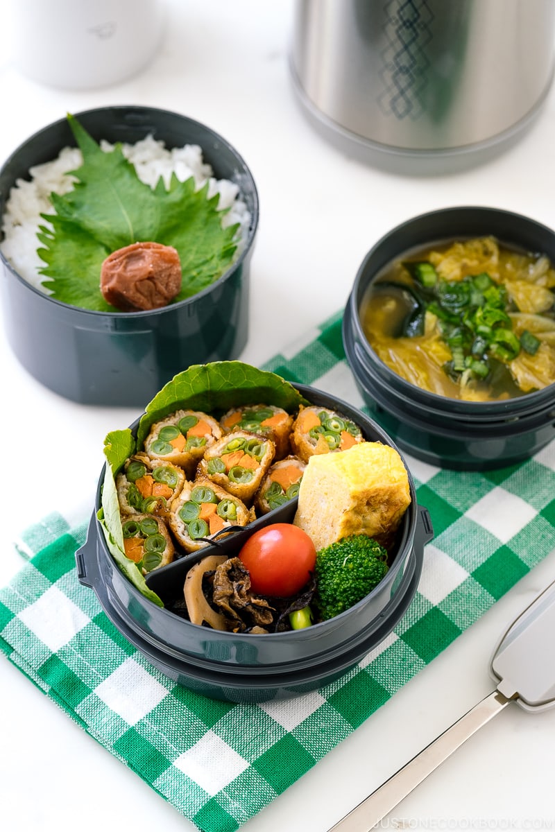 A Zojirushi lunch jar containing rice, pork rolls, and miso soup.